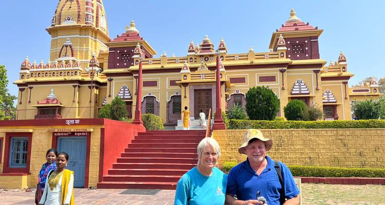 Touristen posieren vor einem bunten Tempelgebäude.