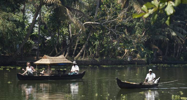 Schilderachtig riviertafereel met lokale bewoners in kano's en weelderig groen.