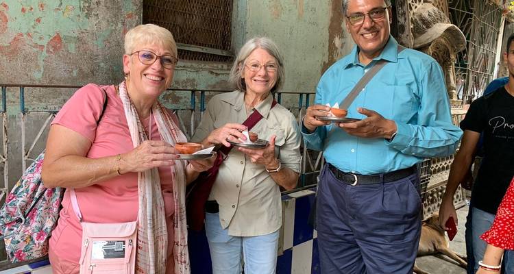 Drei Menschen genießen traditionelle Getränke an einem Straßenstand.