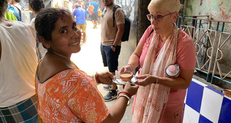 Frau, die einen traditionellen Tonbecher von einem Verkäufer erhält.