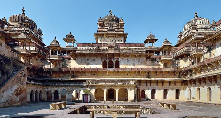 Orchha Palace with domed structures under a clear sky.