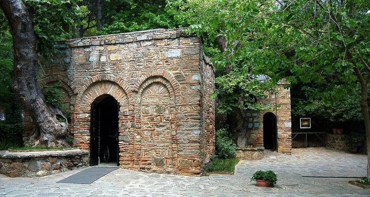 Äußeres eines Steingebäudes, umgeben von Bäumen.