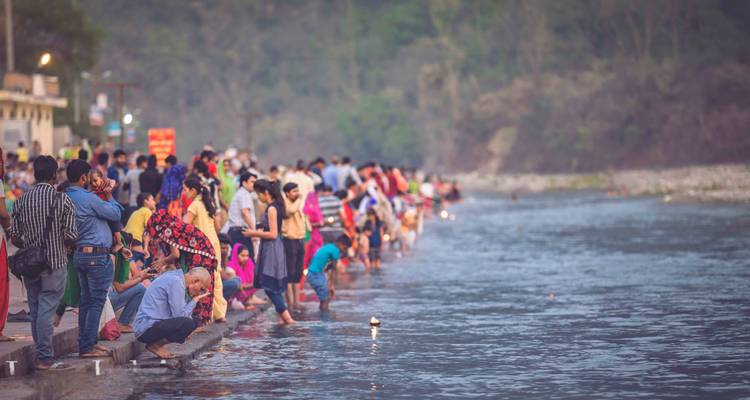 Des gens se sont rassemblés au bord de la rivière pour accomplir des rituels.