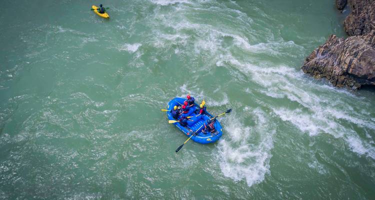 Des personnes faisant du rafting dans une rivière aux eaux tumultueuses.