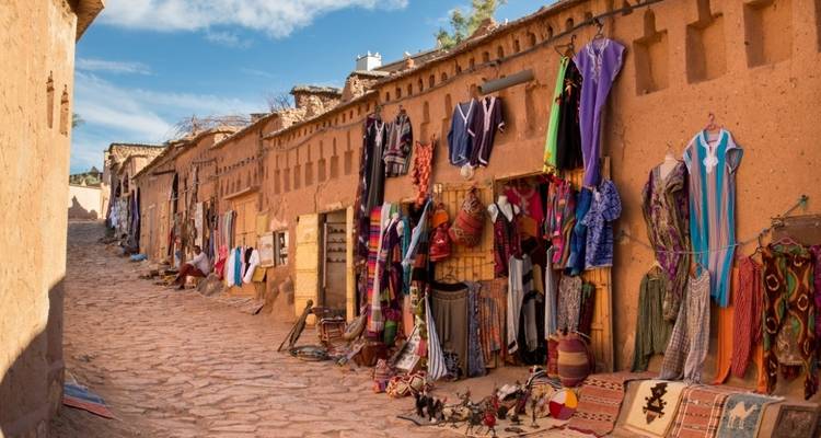 Rustieke steeg met winkels die kleurrijke textiel en handwerk verkopen