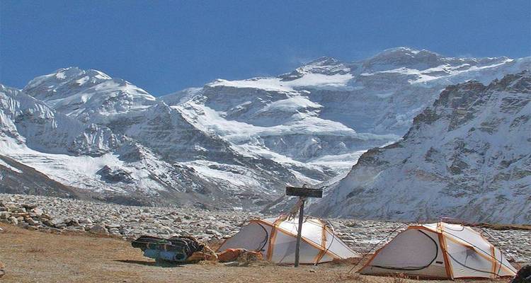 Tenten opgezet in een bergachtig besneeuwd landschap.