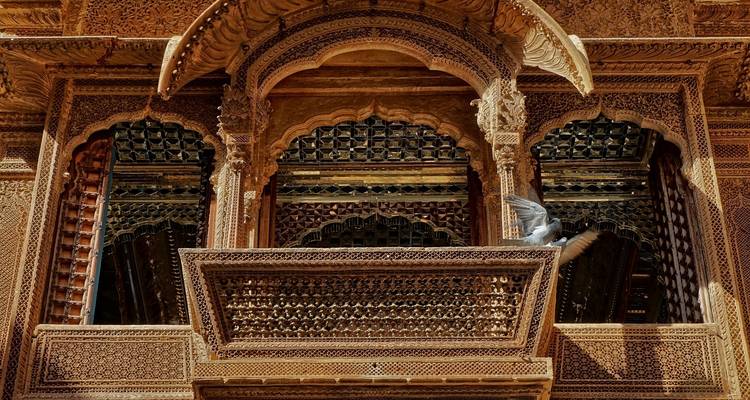 Aufwändig geschnitzte Steinbalkone mit einer Taube, die auf einem sitzt.