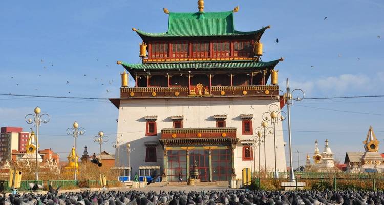 Grand monastère avec des pigeons au premier plan.