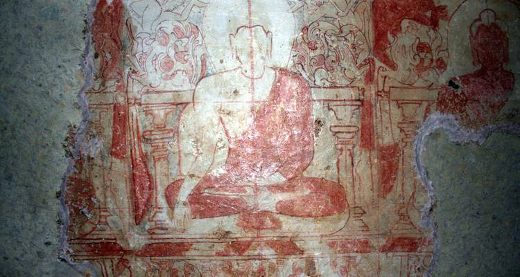 Old fresco of a seated figure with faded colors.