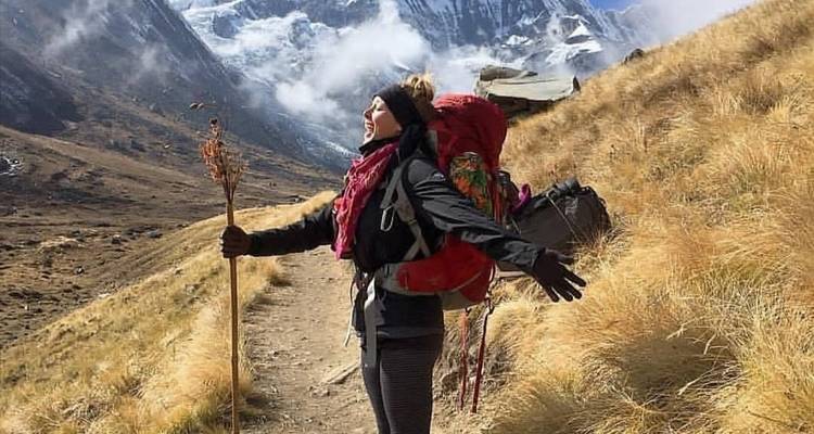 Vrouw met een rugzak geniet van het uitzicht op een bergpad.