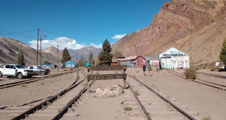 Railway tracks leading to Puente del Inca with mountains in the background.