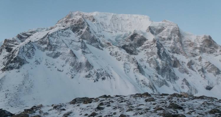 Massieve met sneeuw bedekte berg met een ruig landschap.