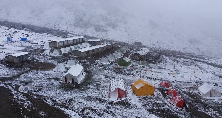 Sneeuwbedekte tenten in een hooggelegen omgeving.