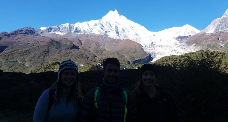 Drie mensen met een bergachtige achtergrond.