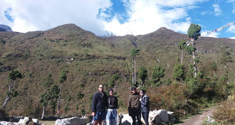 Groep mensen die voor een groene berg staat.