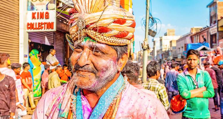 Una persona cubierta de polvo colorido durante una celebración de festival.