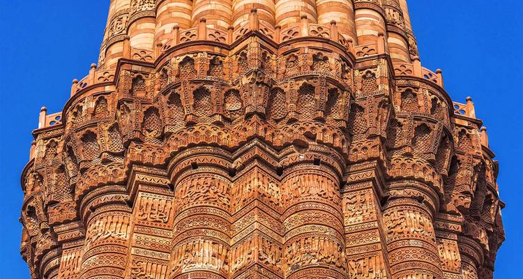 Vista detallada del Qutub Minar con sus impresionantes tallas de piedra.