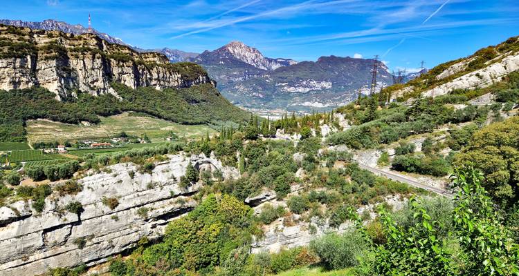 Les falaises de calcaire spectaculaires et les vallées verdoyantes s'étendent sous un ciel bleu éclatant traversé par des traînées de condensation dans le nord de l'Italie.