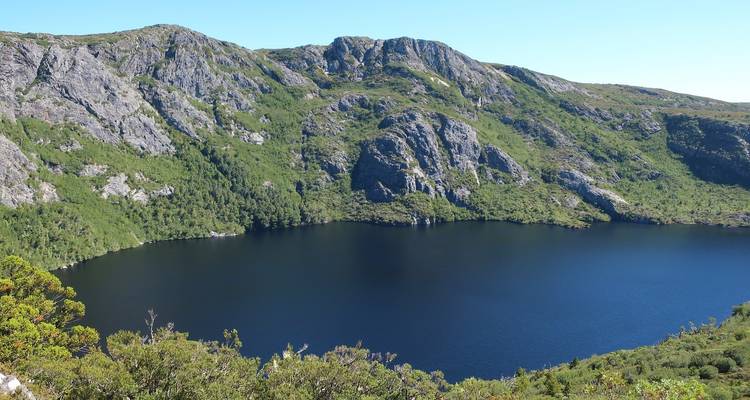 Wunderschöner See mit klarem blauen Wasser, umgeben von felsigen Bergen.