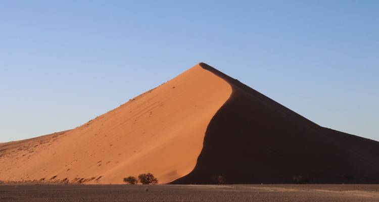 Grande dune de sable avec un ciel dégagé.