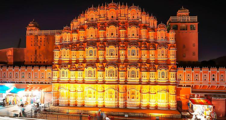 El Hawa Mahal bellamente iluminado contra un cielo oscuro.