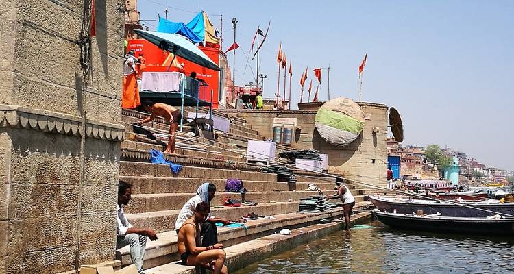 People gathered along stone steps by the river.
Dutch translation: Mensen verzamelden zich langs stenen trappen bij de rivier.