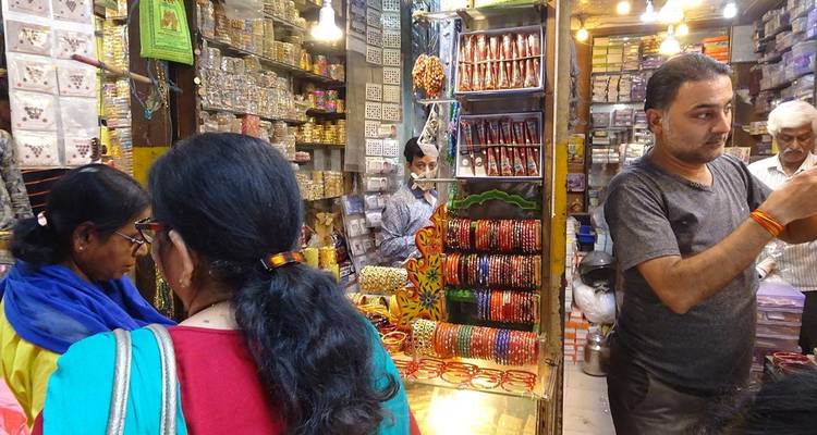 Marktszene mit bunten Armreifen und Waren zum Verkauf.