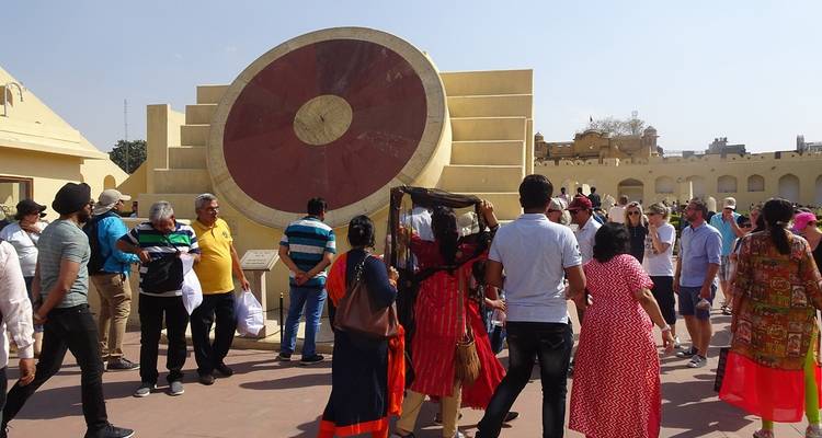 Touristen betrachten eine große Sonnenuhr in einer Sternwarte.