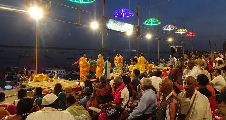 Überfüllte Abendveranstaltung am Flussufer mit Aufführungen.