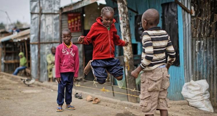 Des enfants jouent à un jeu dans un espace urbain extérieur.
