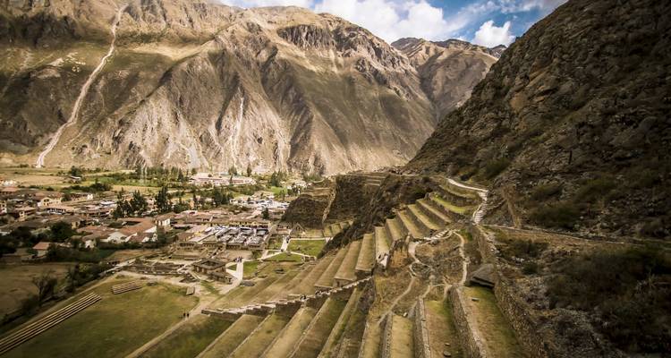 Ancient terrace ruins against a mountainous backdrop.