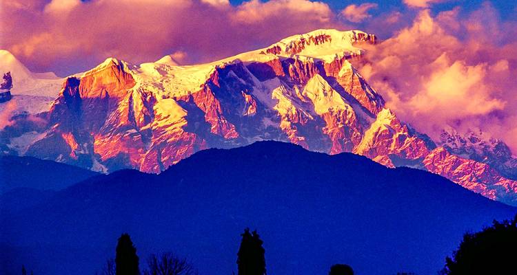 A vibrant mountain view with dramatic clouds at sunset