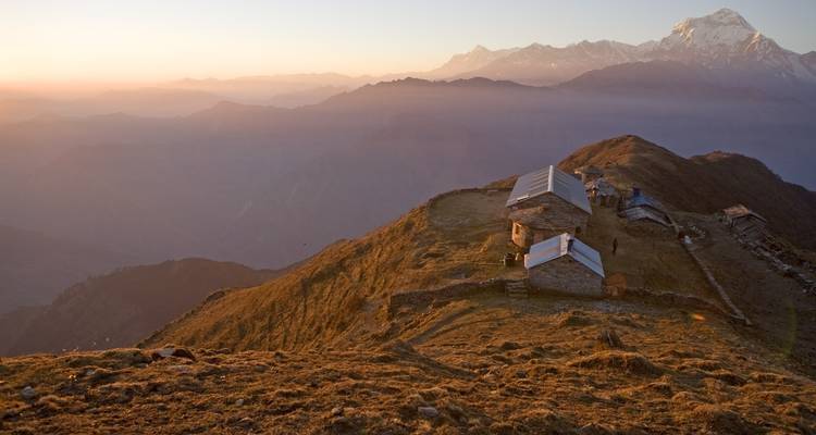 Mountain landscape with small houses at sunset.
