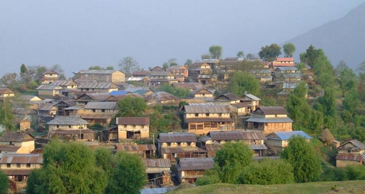 Schmale Häuser drängen sich in einem ländlichen Hügeldorf zusammen.