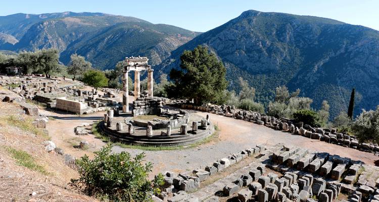 Ruines antiques du site de Delphes avec des montagnes en arrière-plan.
