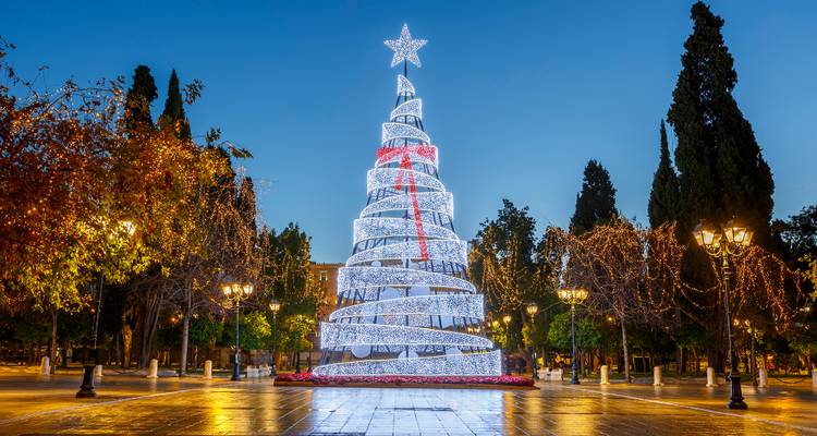 Christmas tree with lights in a public square at night.