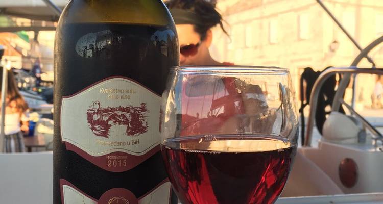 Wijnfles en glas op een tafelblad met wazige achtergrond