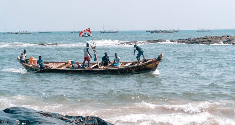 Un groupe de personnes dans un bateau en bois sur l'océan.