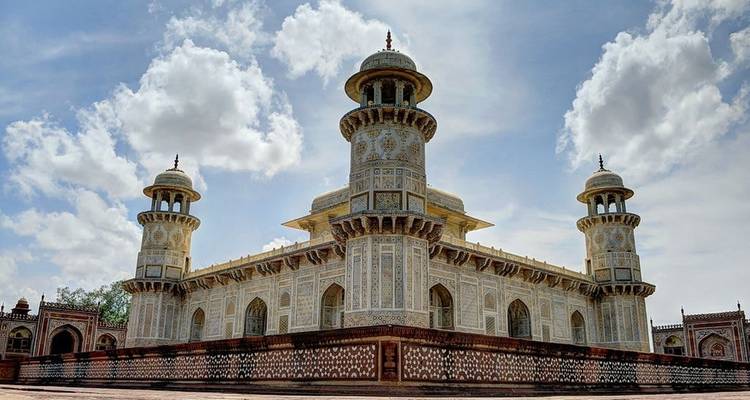 Ornate mausoleum with intricate carvings and blue sky.