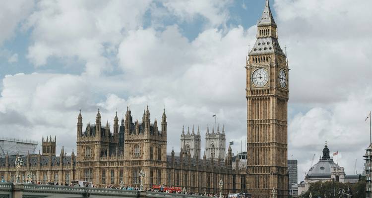 La tour de l'horloge emblématique Big Ben et le Palais de Westminster se dressent au-dessus du Pont de Westminster sous des nuages dramatiques.