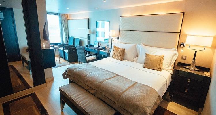 Luxuriöses Interieur eines Hüttenraums mit einem Doppelbett und Sitzbereich.