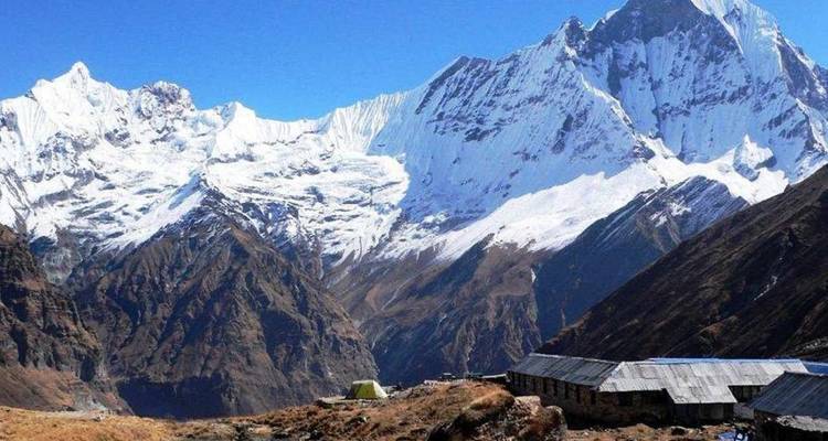 Schneebedeckte Berge mit einer Siedlung im Vordergrund.