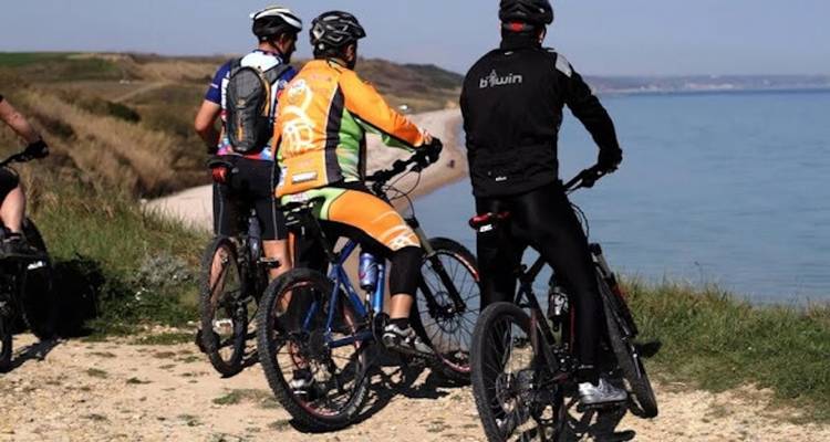 Fietsers die uitkijken over een kustgezicht.