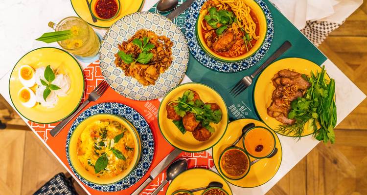 Assortment of colorful Thai dishes served on a table.
