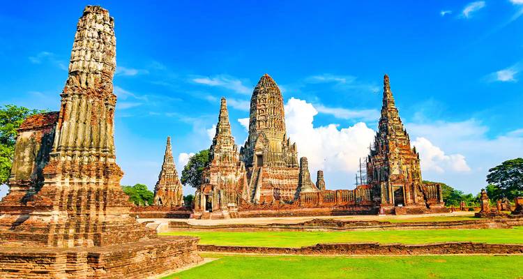 Historic temple ruins with tall spires against a blue sky.