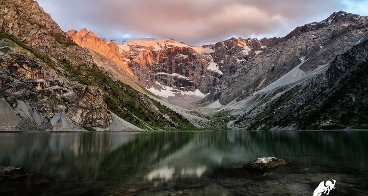 Majestätische Berge spiegeln sich bei Sonnenaufgang in einem ruhigen See wider.
