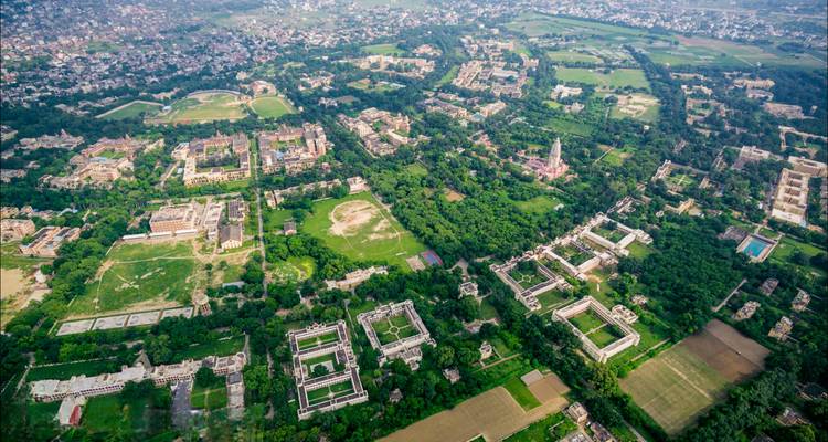 Luftaufnahme der Stadt Varanasi mit vielen Gebäuden und Grünflächen.