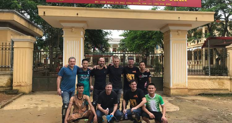 Groep mensen die poseren voor een foto bij een toegangspoort.