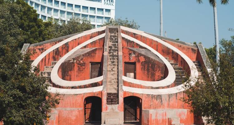 Astronomische Struktur im Jantar Mantar mit einem modernen Gebäude im Hintergrund in Neu-Delhi, Indien.
