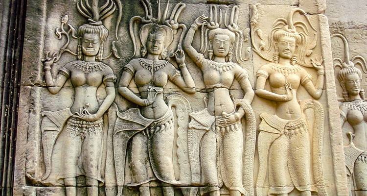 Carvings of Apsara dancers on ancient stone walls.